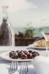 Italy, Atrani, black olives on plate - FLMF00076