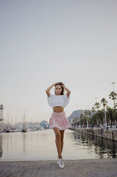 Fashionable young woman posing at the harbour of Barcelona, Spain - AFVF01619