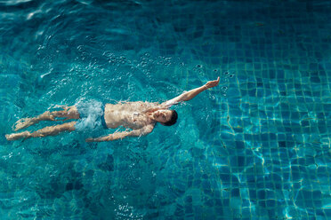 High angle view of shirtless man swimming in pool at resort - CAVF48777