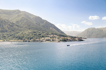 Scenic view of sea against mountains and sky during sunny day - CAVF48786