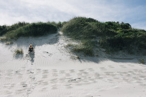 Junge spielt im Sand am Strand im Sommer - CAVF48805