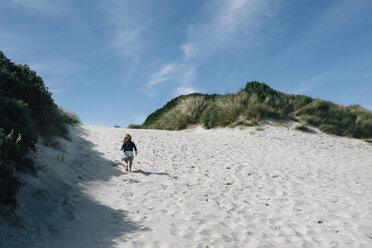 Rückansicht eines Mädchens, das im Sommer am Strand auf Sand läuft - CAVF48806