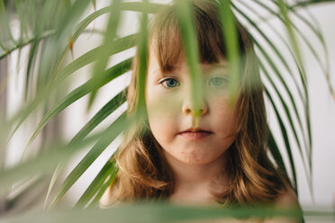 Porträt eines Mädchens inmitten von Blättern zu Hause - CAVF48821