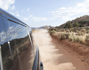 Black car on dirt road at desert - CAVF48843