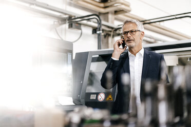 Manager talking on the phone in high tech company - KNSF04781