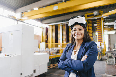 Young woman working in distribution warehouse, wearing VR glasses - KNSF04797