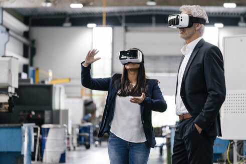 Businessman an woman in high tech enterprise, using VR glasses - KNSF04803