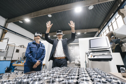 Businessman and skilled worker in high tech enterprise, using VR glasses - KNSF04818