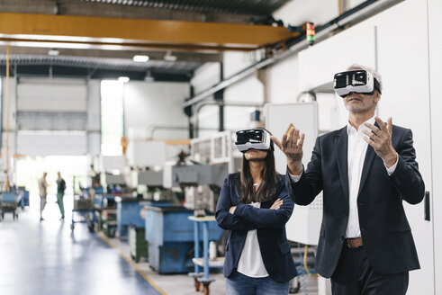 Businessman an woman in high tech enterprise, using VR glasses - KNSF04839