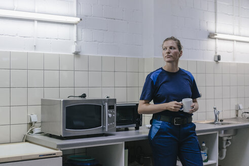 Young woman working in high tech enterprise, taking a break, drinking coffee - KNSF04850