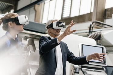 Businessman and skilled worker in high tech enterprise, using VR glasses - KNSF04855