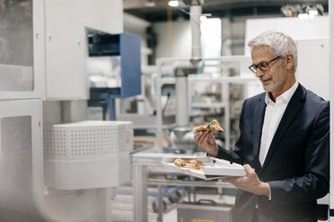 Manager in einem Hightech-Unternehmen, der Pizza isst - KNSF04863