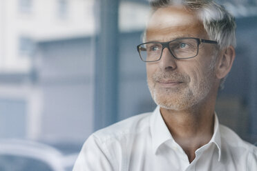 Successful manager looking out of window, thinking, portrait - KNSF04870