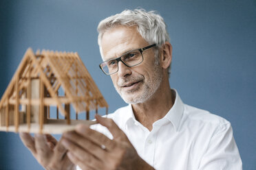 Successful architect looking at model of a house - KNSF04873