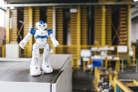 Toy robot standing on shelf in logistics center stock photo