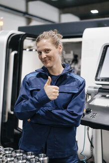 Young woman working as a skilled worker in a high tech company, giving thumbs up - KNSF04939