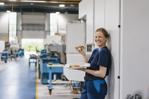 Woman working in high tech company, taking a break, eating pizza - KNSF04952