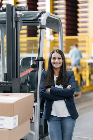 Confident woman standing in logistics center, with arms crossed stock photo