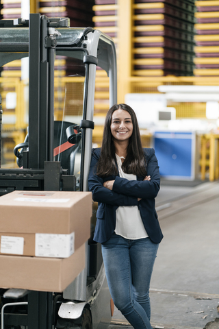 Confident woman standing in logistics center, with arms crossed stock photo