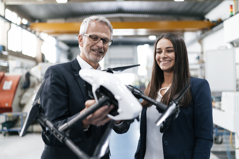 Geschäftsmann und Frau in einem Hightech-Unternehmen, die über die Produktion von Drohnen diskutieren, lizenzfreies Stockfoto