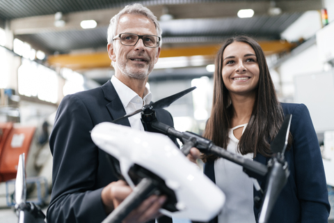 Geschäftsmann und Frau in einem Hightech-Unternehmen, die über die Produktion von Drohnen diskutieren, lizenzfreies Stockfoto