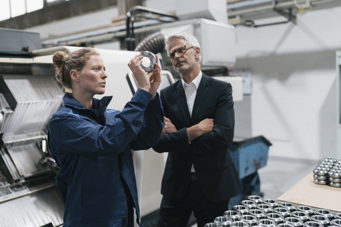 Manager und Facharbeiter in einem High-Tech-Unternehmen, Prüfung von Maschinenteilen, lizenzfreies Stockfoto