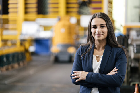 Confident woman standing in logistics center, with arms crossed - KNSF04991