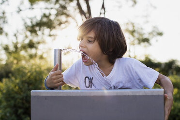 Little boy drinking water from an outdoor tap - AZOF00061