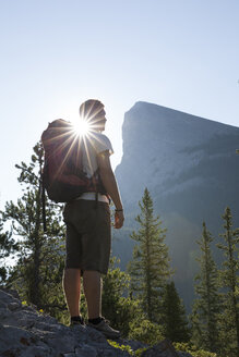 Wanderer blickt vom Bergrücken aus auf die Berge, Sonnenaufgang - AURF06427