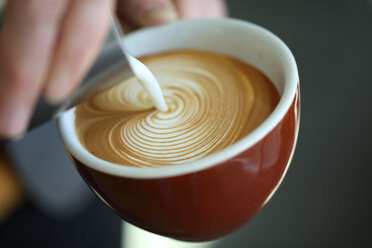 Barista gießt Milch in einen Cappuccino, Oakland, Kalifornien, USA - AURF06498