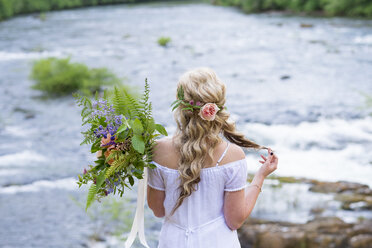 Braut im Hochzeitskleid mit Blumenstrauß am Ufer des North Umpqua River, Glide, Oregon, USA - AURF06503