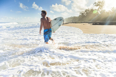 Pancho Sullivan mit seinem Surfbrett auf dem Strand von Rocky Point an der Nordküste von Oahu, Hawaii - AURF06650