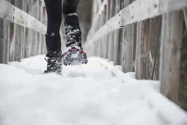 Person beim Schneeschuhwandern auf dem Steg im Winter - AURF06685