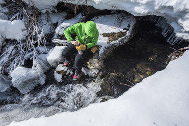 Person beim Sammeln von Wasser aus dem Cutler River in den White Mountains, New Hampshire, USA - AURF06686