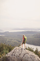 Weibliche Wanderin steht und betrachtet die Aussicht auf dem Gipfel des Pemetic Mountain, Acadia National Park, Maine, USA - AURF06799