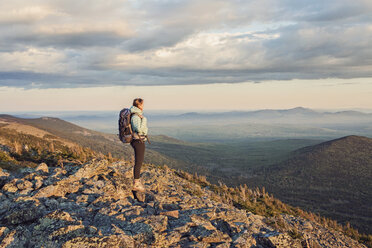 Wanderin steht und bewundert die Landschaft vom Gipfel des Mount Abraham in der Abenddämmerung, Maine, USA - AURF06800