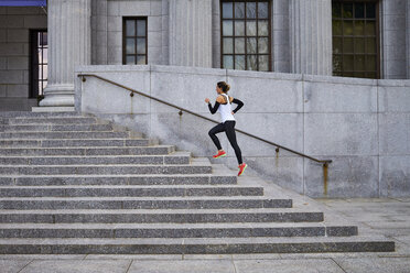 Female jogger running up steps of city building, Boston, Massachusetts, USA - AURF06811