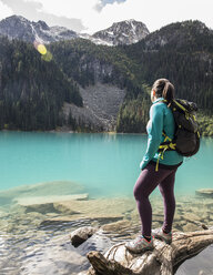 Female backpacker standing on shore of Middle Joffre Lake, Duffy Lake Provincial Park, Pembreton, British Columbia, Canada - AURF06820