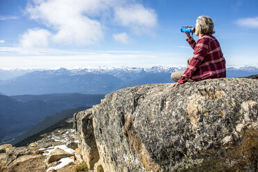 Wanderin, die sich ausruht und Wasser trinkt, auf dem Gipfel des Whistler Mountain, Garibaldi Provincial Park, Whistler British Columbia, Kanada - AURF06821