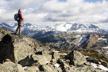 Female hiker looking at view of Garibaldi Provincial Park from top of Whistler Mountain, Whistler, British Columbia, Canada - AURF06823