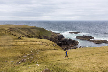 Female jogger running along highland coastline, Scotland, UK - AURF06824