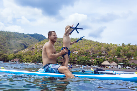 Vater und Sohn auf einem Surfbrett, Bali, Indonesien., lizenzfreies Stockfoto