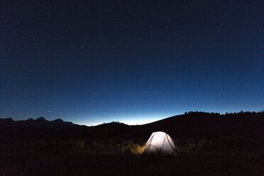 Beleuchtetes Zelt unter nächtlichem Sternenhimmel, Ausläufer der Sawtooth Wilderness, Stanley, Idaho, USA - AURF06916