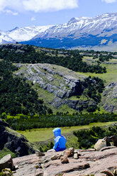 Wanderer sitzt in einer Landschaft mit Bergen, El Chalten, Provinz Santa Cruz, Patagonien, Argentinien - AURF06924