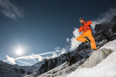 Eiskletterer auf einem Bein stehend in den verschneiten Bergen der österreichischen Alpen, Felbertauern, Salzburg, Österreich - AURF06983