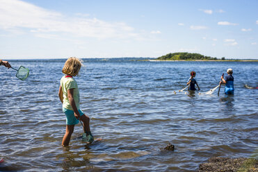 Mädchen mit Fischernetz und Fischer im Meer, Bristol, Rhode Island, USA - AURF06990