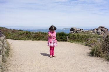 Front view of sulking young girl on beautiful summer day in Ploumanach, Brittany, France - AURF07020