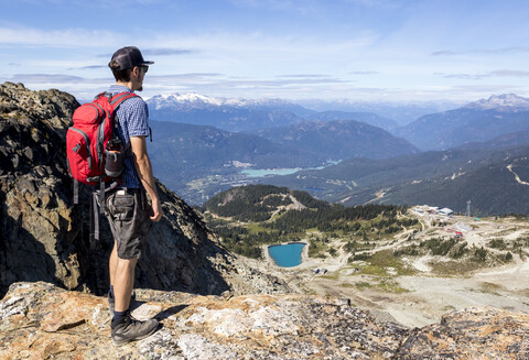 Männlicher Wanderer bewundert die Landschaft um das Skigebiet Whistler Blackcomb, Whistler, British Columbia, Kanada, lizenzfreies Stockfoto