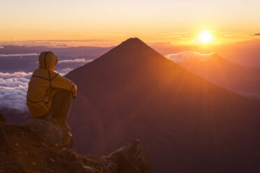 Mann beim Blick auf den Sonnenaufgang vom Gipfel des Vulkans Acatenango, Guatemala - AURF07096