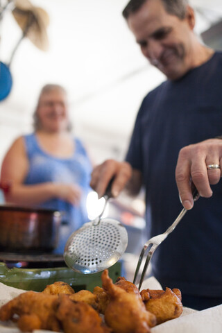 Mann bei der Zubereitung traditioneller holländischer Oliebollen-Krapfen, Langley, British Columbia, Kanada, lizenzfreies Stockfoto